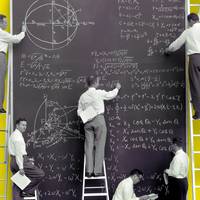 des mathématiciens écrivent des équations sur un tableau noir